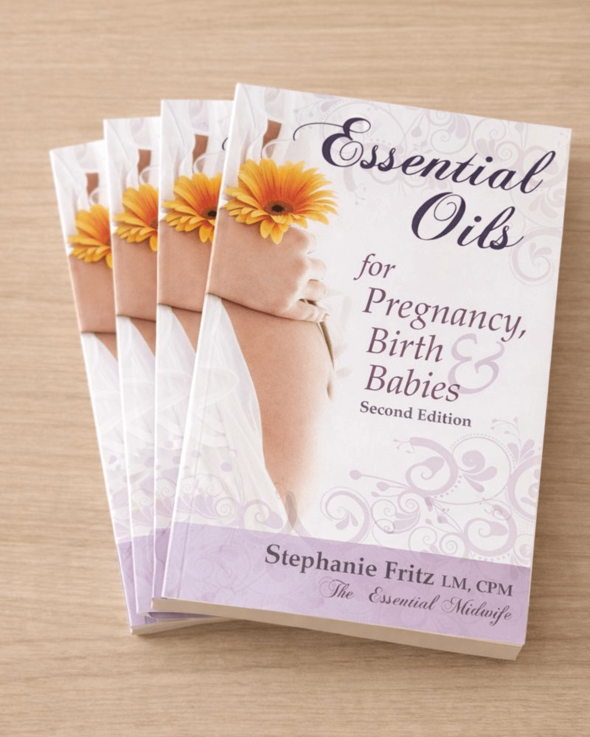 Paperback book titled “Essential Oils for Pregnancy, Birth and Babies” by Stephanie Fritz displayed on a neutral surface.