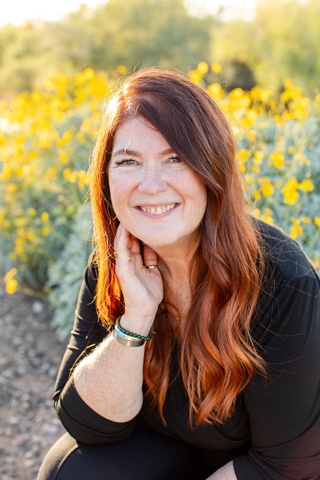 Midwife educator sitting in outdoors in natural light, smiling gently.